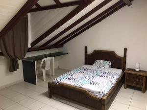 ein Schlafzimmer mit einem Bett und einem Schreibtisch. in der Unterkunft SCI AZUR in Basse-Terre