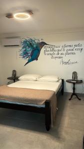 1 dormitorio con 1 cama con un pavo real en la pared en Villa de 5 chambres avec vue sur la mer piscine privee et jardin clos a Le Carbet a 1 km de la plage, en Le Carbet