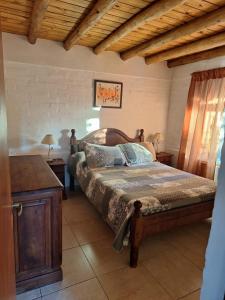 ein Schlafzimmer mit einem Bett mit einem hölzernen Kopfteil in der Unterkunft Los Niyus in San Rafael