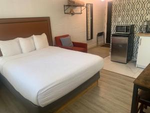 um quarto de hotel com uma cama e uma cadeira em The Spot em Nanaimo