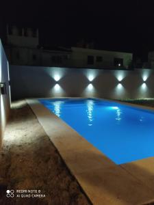 Casa 3 dormitorios. - Barrio Valle Cercano في قرطبة: حمام سباحة في الليل مع وجود أضواء عليه