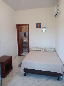 Schlafzimmer mit einem Bett und einem Holztisch in der Unterkunft Suítes da Alcy in Caraíva