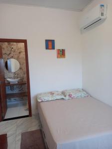 a small bedroom with a bed and a sink at Suítes da Alcy in Caraíva