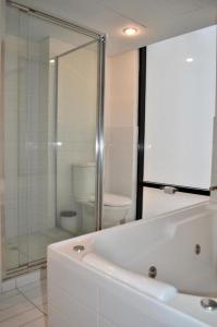 a bathroom with a shower and a tub and a toilet at CBD Executive APT in Adelaide