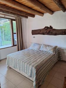 a bedroom with a bed with a log on the wall at Los Niyus in San Rafael +45 photos