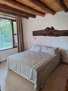 a bedroom with a bed with a log on the wall at Los Niyus in San Rafael