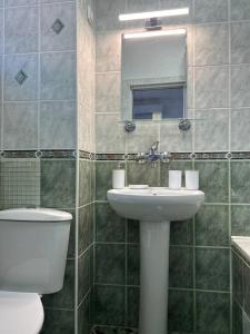 a bathroom with a sink and a toilet and a mirror at Pirostka Vintage Room in Sofia