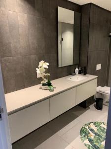 a bathroom with a sink with a vase of flowers at The Quarter Mountain View Haven at Waterkant in Cape Town