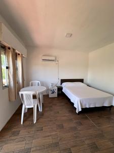 Schlafzimmer mit einem Bett, einem Tisch und Stühlen in der Unterkunft Departamentos LT1 in Las Toscas
