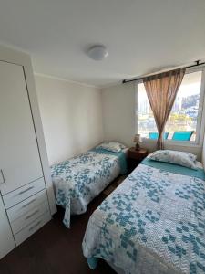 a bedroom with two beds and a window at Viña del Mar - Parque Marina in Viña del Mar +5 photos