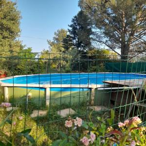 uma cerca em torno de uma piscina num quintal em Maison familiale Sud Drôme-Ardèche em Châteauneuf-du-Rhône
