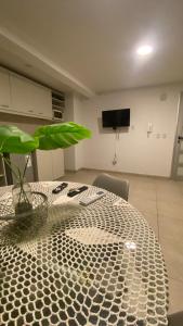 Habitación con mesa con planta y TV. en Departamento TIERRA V en Salta