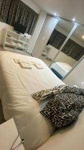 1 cama blanca grande en una habitación con espejo en Departamento TIERRA V en Salta