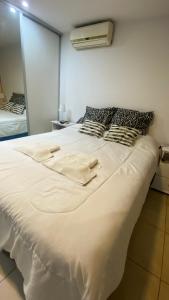 1 cama blanca grande en una habitación con espejo en Departamento TIERRA V en Salta