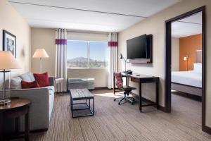 a hotel room with a bed and a desk with a computer at Four Points by Sheraton at Phoenix Mesa Gateway Airport in Mesa