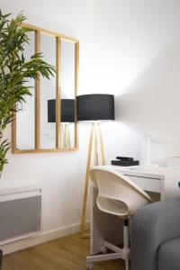 Blain的住宿－Le Beverley Studio，一张桌子,墙上挂着一盏灯和一面镜子