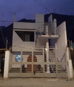 a white house with a gate in front of it at El Valle Lunahuaná in Lunahuaná