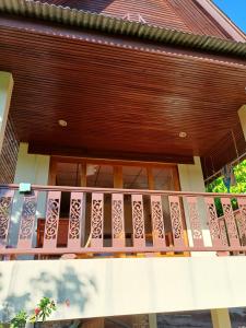 een balkon van een huis met een houten leuning bij Tropicana Khophagan Resort Hotel in Thongsala