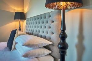 a bedroom with a bed with pillows and a lamp at Kaikoura Boutique Hotel in Kaikoura