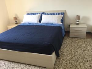 1 dormitorio con 1 cama con colcha azul y 2 mesitas de noche en Casa Annalisa en Venecia
