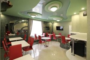 a dining room with tables and red chairs at Boutique Hotel Absolute in Saratov
