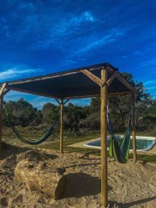 a canopy with a hammock in the sand next to a pool at Rinkeby in La Esmeralda 