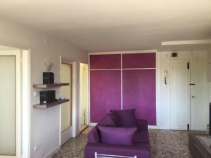 ヴェネツィアにあるカーザ アナリーザの紫色のソファと紫色の壁が備わるリビングルーム