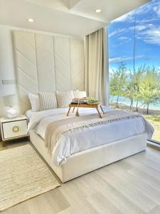 a bedroom with a large bed with a table on it at Lazzlla beach front apartments in Hulhumale