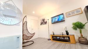 a living room with a rattan chair and a mirror at PPL Apartments in Sheffield