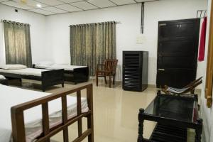 Habitación con 2 camas, mesa y sillas en Aqualillies Water Front Heritage Homestay, en Kumarakom