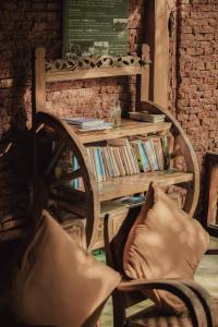 a chair and a book shelf with books at Villa Lumbung in Ubud