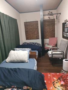 a room with two beds and a chair and a couch at MIROKU Share House in Mimiharachō