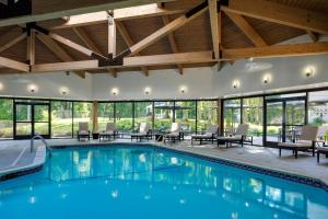 a swimming pool with tables and chairs in a building at Portland Sheraton at Sable Oaks in South Portland