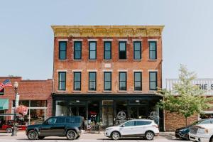a brick building with cars parked in front of it at East Main Lofts - Coastal 201 in Madison