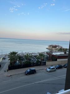 a parking lot with cars parked next to the ocean at Odore di Mare con Jacuzzi in Durrës +11 photos