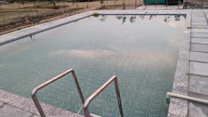 un charco de agua con dos rieles metálicos. en Agvani Resort, en Bera