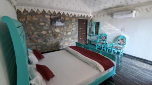 1 dormitorio con 1 cama, mesa y sillas en Agvani Resort, en Bera