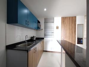 una cocina con armarios azules y fregadero en Acogedor Apartaestudio Trento 21 Ciudad Jardín Popayan, en Popayán