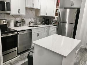 a kitchen with white cabinets and a stainless steel refrigerator at SUITE B - Private Cozy, Spacious Suite with Private Bathroom in Bowie