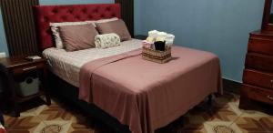 a bedroom with a bed with a red headboard at Casa Victoria in San Benito