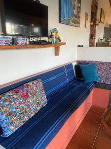 Sofá azul en una habitación con TV en Secret Springs, en Tilarán