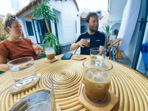 un hombre y una mujer sentados en una mesa con bebidas en Santa Fe House - Gành Đá Đĩa en Phú Hạnh (5)