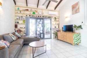 ein Wohnzimmer mit einem Sofa und einem Tisch in der Unterkunft Tropical Garden Villa 5 mins from City Centre in Parap
