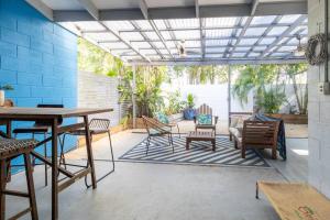 un patio con mesa de madera y sillas en Tropical Garden Villa 5 mins from City Centre en Parap