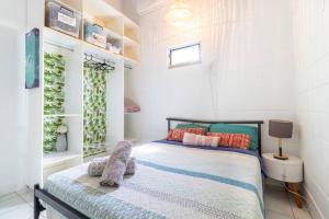 een slaapkamer met een bed met een knuffeldier erop bij Tropical Garden Villa 5 mins from City Centre in Parap