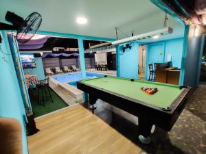 a pool table in a room next to a swimming pool at Casa Maris in Bacoor