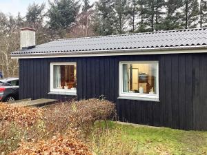 a black house with two windows in a yard at Holiday home Esbjerg V XI in Esbjerg