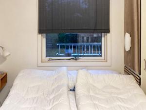 a white bed sitting in front of a window at Holiday home Esbjerg V XI in Esbjerg