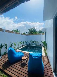 een zwembad met blauwe kussens op een houten terras bij Villa Damai in Dalung