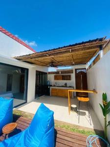 een patio met een tafel en stoelen en een dak bij Villa Damai in Dalung